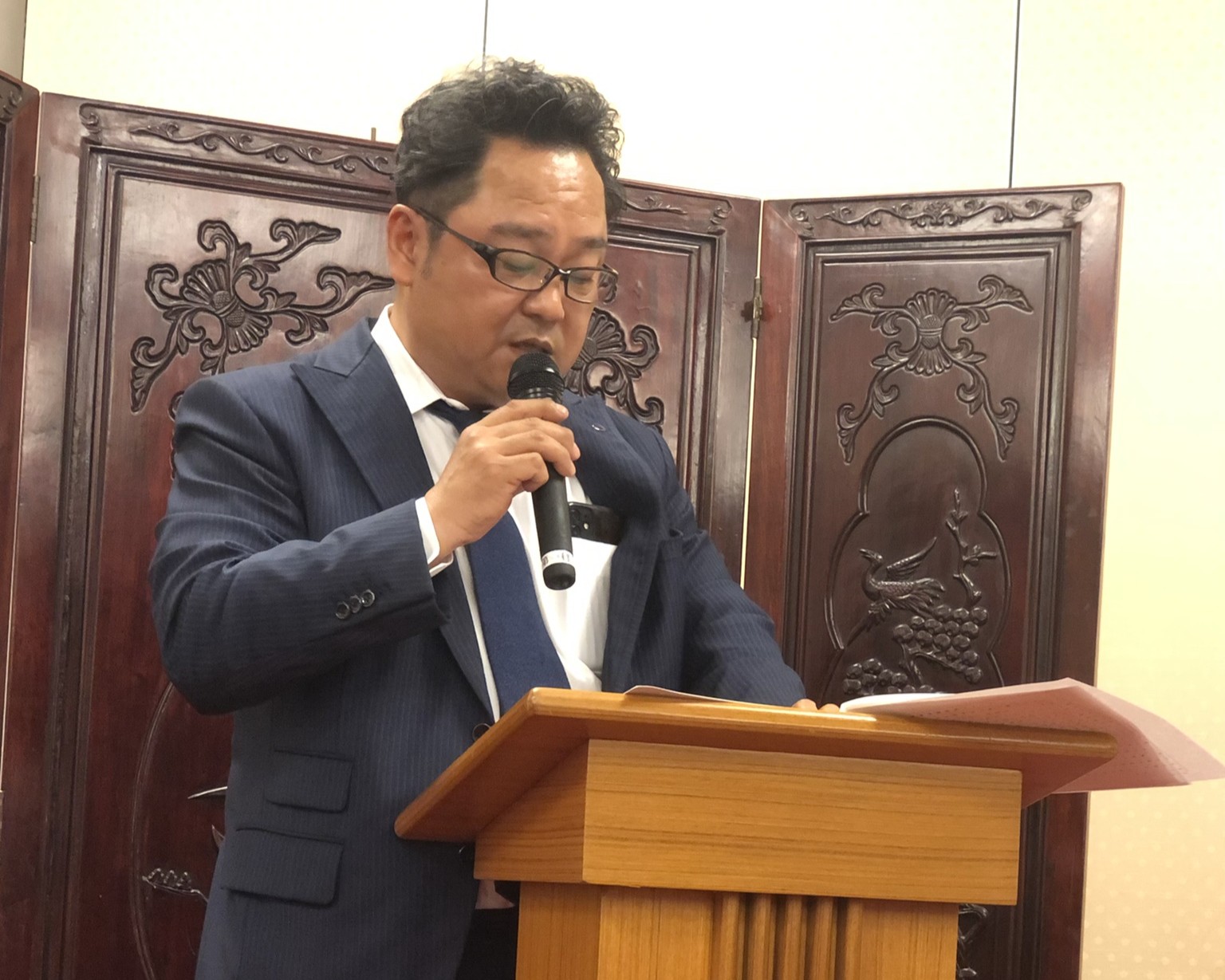 マイクを持って話す男性